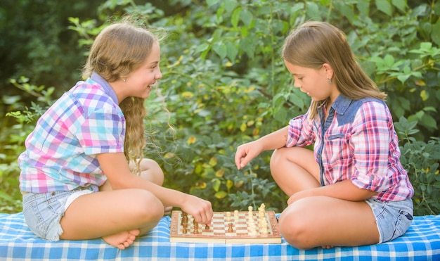 Meine an der Reihe würdigen Gegner entwickeln verborgene Fähigkeiten. Zwei konzentrierte Mädchen spielen Schach. Schachspielende Schwestern. Geschickte Kinder. Schalten Sie Ihr Gehirn ein. Lassen Sie das Gehirn arbeiten. Frühkindliche Entwicklung