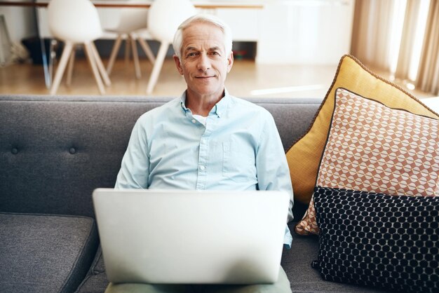 Meine Komfortzone hat Konnektivität Schnappschuss eines älteren Mannes, der sich entspannt und einen Laptop auf dem Sofa zu Hause benutzt