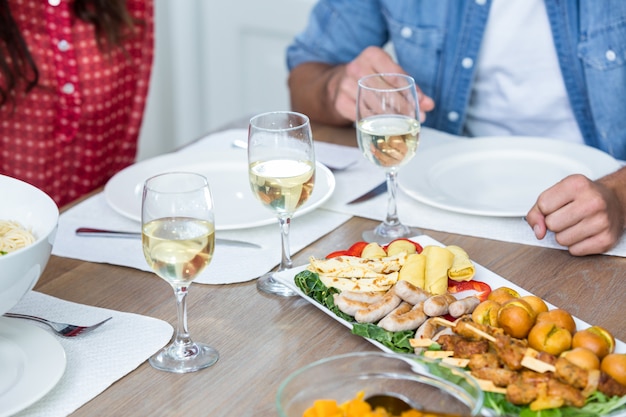 Meio de pessoas com comida servida na mesa