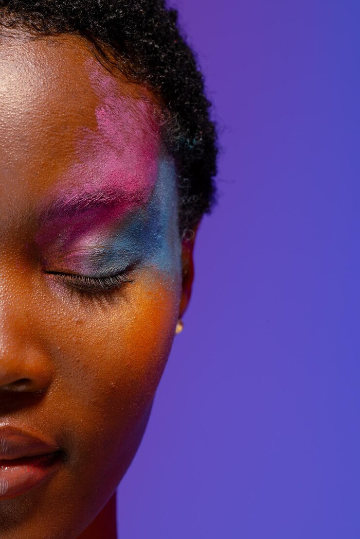 Foto meio retrato de mulher afro-americana com cabelo curto e maquiagem colorida com os olhos fechados