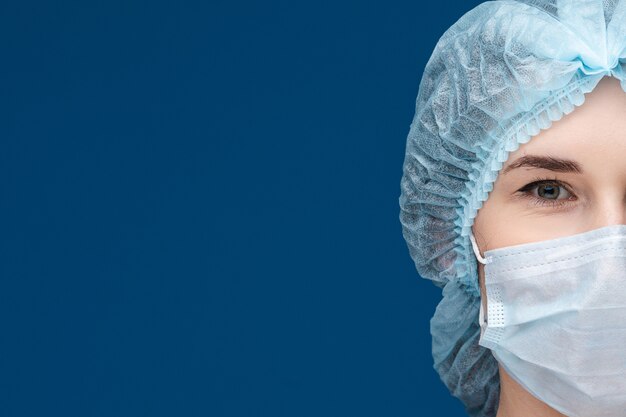 Meio retrato do médico em máscara facial e chapéu.