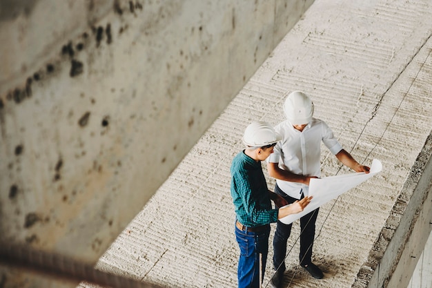 Meister und Architekt sprechen über heiß, um die Arbeit zu verbessern und wie die Arbeitsgeschwindigkeit am Gebäude im Bau erhöht werden kann.