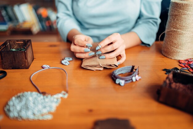 Meisterin mit Schere macht handgemachten Ohrring