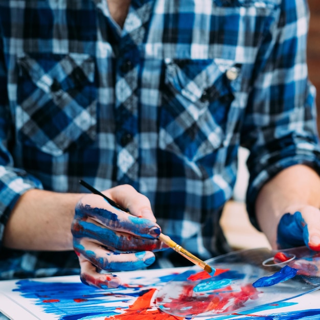 Meisterklasse für bildende Kunst Kreativer Prozess Schnappschuss eines Mannes, der mit Palette und Pinsel an seinem abstrakten Gemälde arbeitet