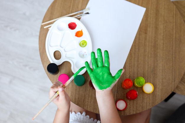 Meisterklasse für Kinder im Zeichnen Das Kind macht einen Handabdruck mit Farbe