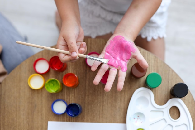 Meisterklasse für Kinder im Zeichnen Das Kind macht einen Handabdruck mit Farbe