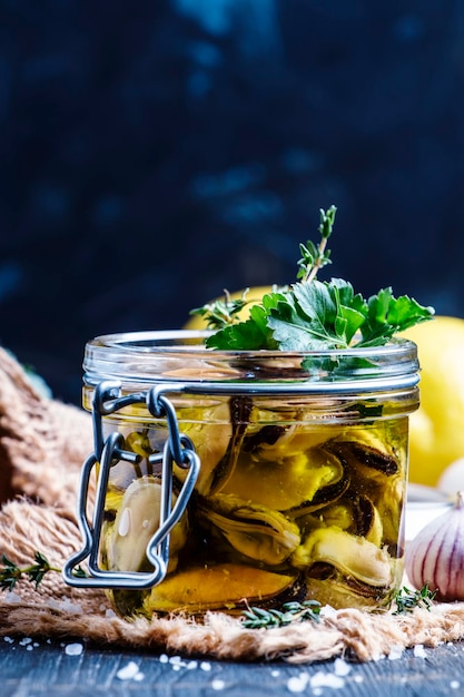 Mejillones en aceite de oliva con limón y hierbas enfoque selectivo de fondo oscuro