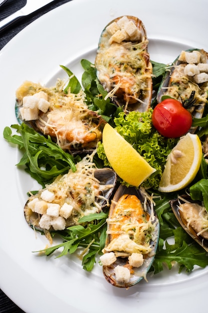 Mejillones al horno con hierbas, vino blanco y parmesano.