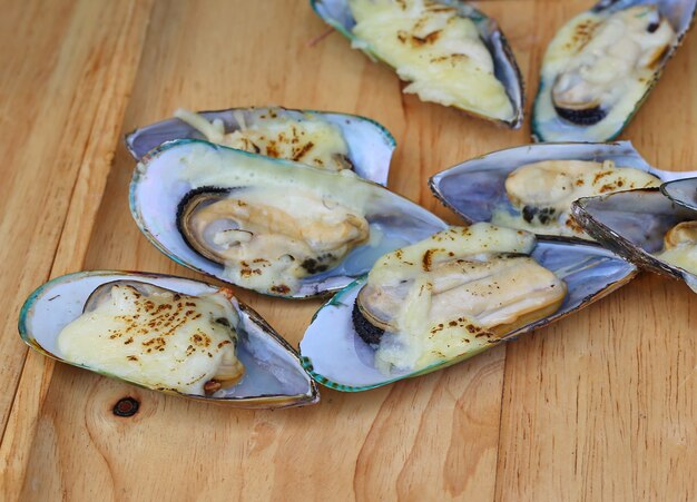 Mejillones al horno con mantequilla servidos en bandeja de madera