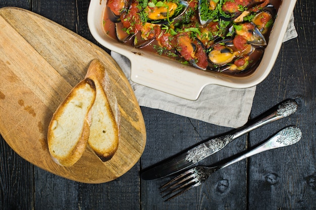 Mejillones al horno en salsa de tomate con cilantro y parmesano.