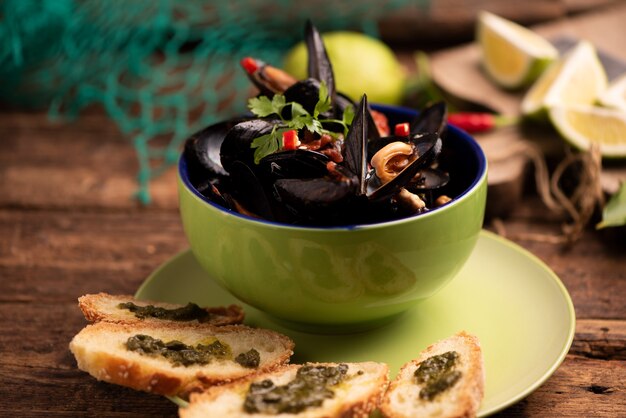 Mejillones cocidos en un plato de cocina sobre fondo de madera