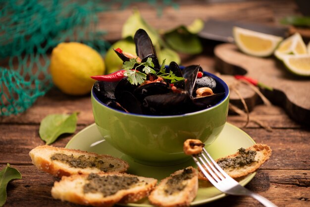 Mejillones cocidos en un plato de cocina sobre fondo de madera