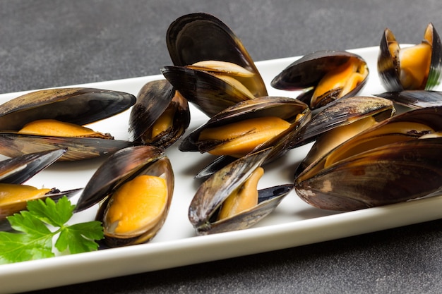 Mejillones con conchas abiertas en un plato blanco. Mariscos mariscos. De cerca. Vista superior.