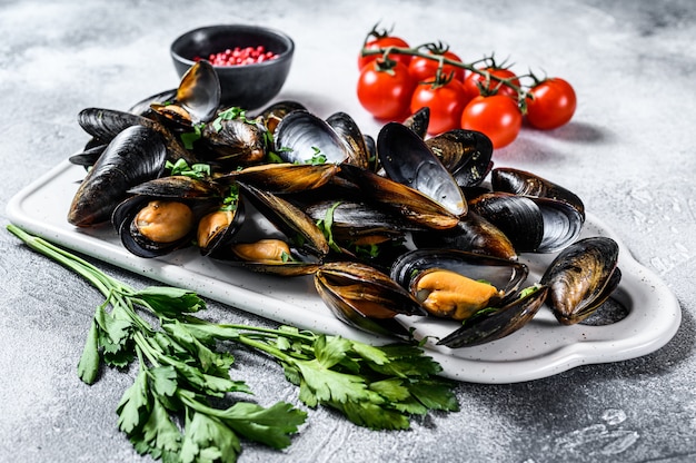 Mejillones crudos frescos en conchas. El concepto de cocinar en salsa de tomate con perejil