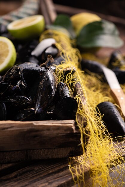 Foto mejillones frescos crudos de ganzirri messina en mostrador en el mercado de pescado local. de cerca