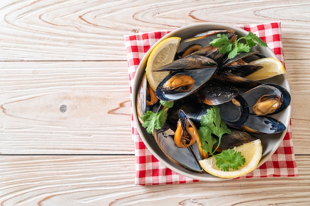 mejillones frescos con hierbas en un bol con limón