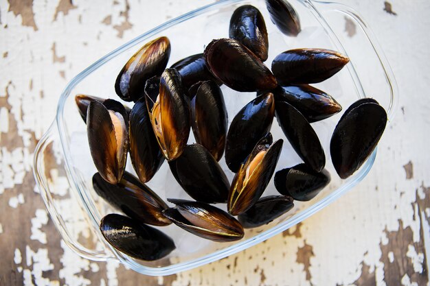 Mejillones frescos en una vieja mesa de madera blanca