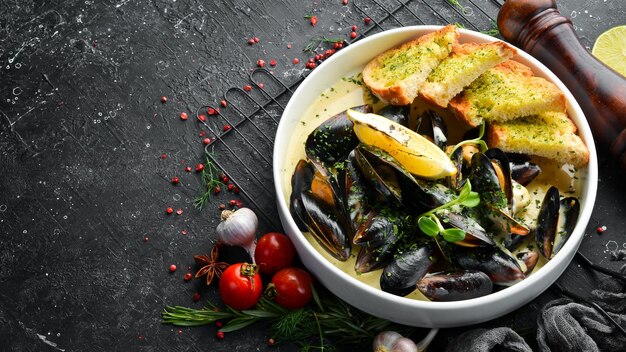 Mejillones hervidos en salsa de crema y ajo Vista superior Espacio libre para texto