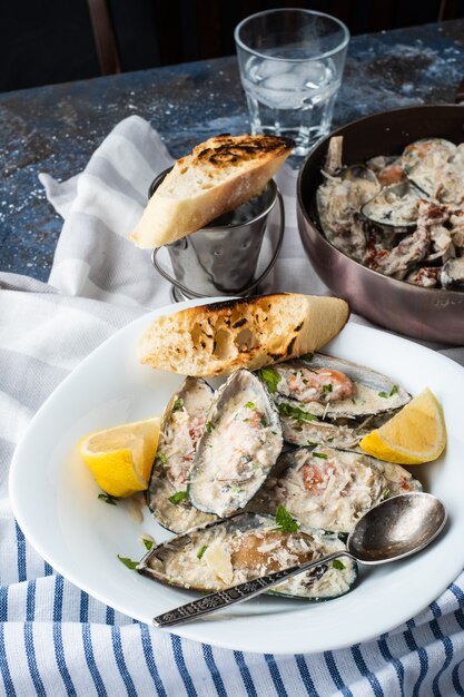 Mejillones con salsa de queso azul y baguette de ajo.