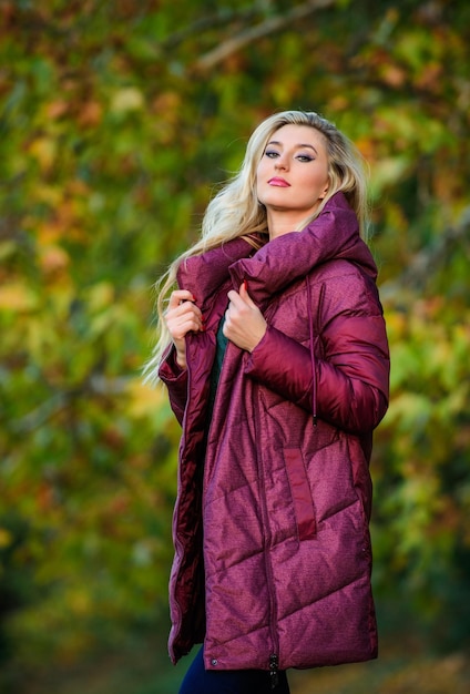 Mejor abrigo puffer para comprar Cómo elegir chaqueta Puffer concepto de moda Consejos de estilistas profesionales Mujer usar chaqueta de volumen extra Chica de moda rubia caminar otoño parque Chaquetas que todos deberían tener