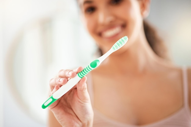 El mejor cepillo de dientes Foto de una mujer joven cepillándose los dientes en casa