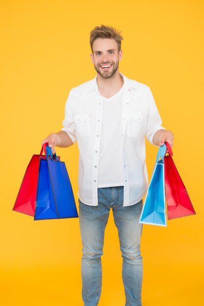 La mejor manera de relajarse Cómo ahorrar dinero mientras se venden productos de concepto de lunes cibernético para hombres chico feliz por su compra compras exitosas en línea comprador masculino sostiene paquetes bolsa de compras con productos