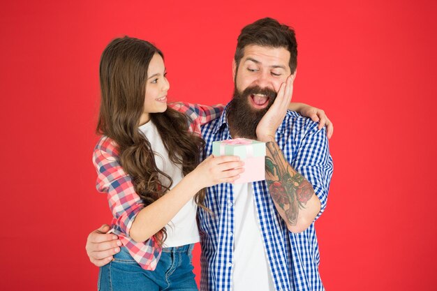 Para el mejor papá Celebre el día del padre Concepto de valores familiares Relaciones amistosas Padre hipster y su hija Regalo sorpresa Hombre barbudo padre e hija linda niña sobre fondo rojo