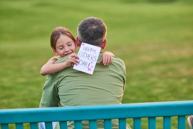 El mejor papá nunca linda niña abrazando a su papá mientras lo saluda y le da una postal hecha a mano