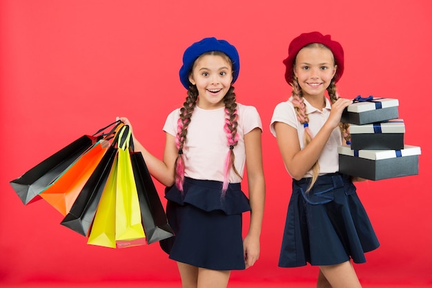 Mejor precio Compre ahora Visite el centro comercial Las niñas sostienen un montón de bolsas de compras o paquetes de regalos de cumpleaños Los sueños se hacen realidad Infancia feliz Concepto de compras Niñas pequeñas y lindas en un tour de compras