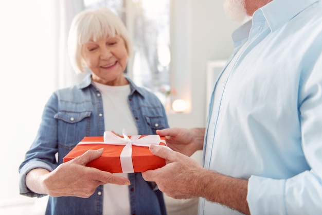 El mejor regalo. La atención se centra en las manos de un apuesto hombre bien formado que recibe un regalo de su amada esposa felicitándolo por su cumpleaños.