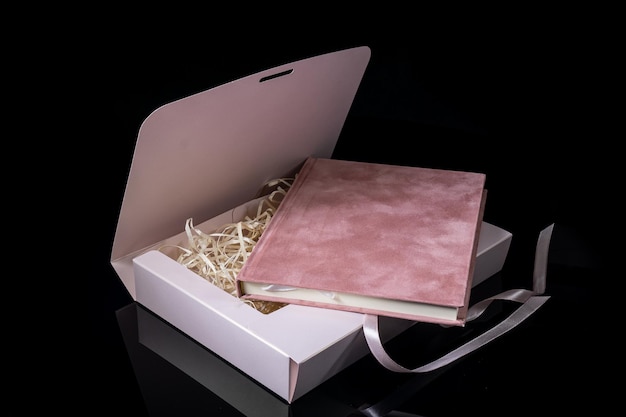 Foto el mejor regalo para hombres concepto de regalo de hombre cuaderno rosa con caja de regalo rosa sobre fondo negro texto de espacio de copia cumpleaños de boda de san valentín y concepto de regalo para ocasiones especiales espacio de copia para texto