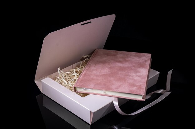 Foto mejor regalo para hombres concepto de regalo para hombres cuaderno rosa con caja de regalo rosa sobre fondo negro copia el texto de espacio día de san valentín, cumpleaños de boda y concepto de regalo para ocasiones especiales copia el espacio para el texto