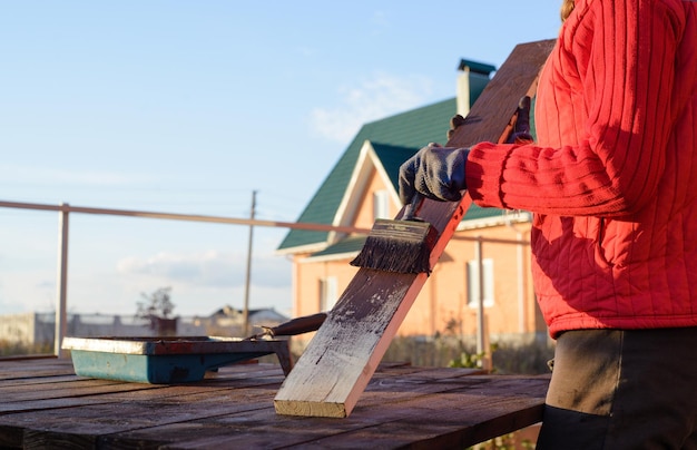 Mejoras para el hogar handywoman pintando tablones de madera al aire libre