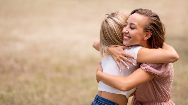 Mejores amigos abrazándose con espacio de copia