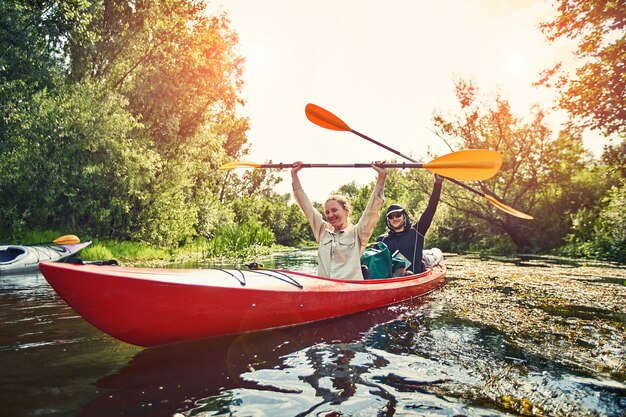 Mejores amigos felices divirtiéndose en kayaks. Kayak en el río.