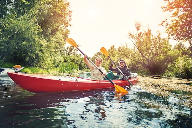 Mejores amigos felices divirtiéndose en kayaks. Kayak en el río.