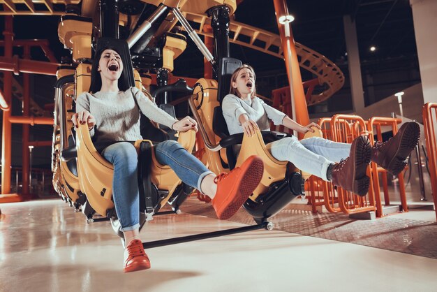 Mejores amigos gritando de miedo en el parque de atracciones.