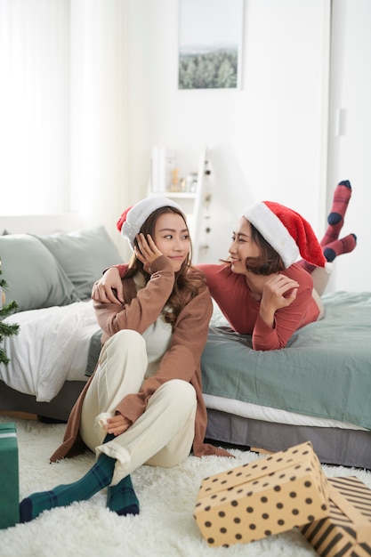 Mejores amigos de mujer joven celebrando la Navidad en casa