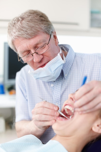 Para mejores dientes Retrato de paciente femenino con dentista trabajando en sus dientes