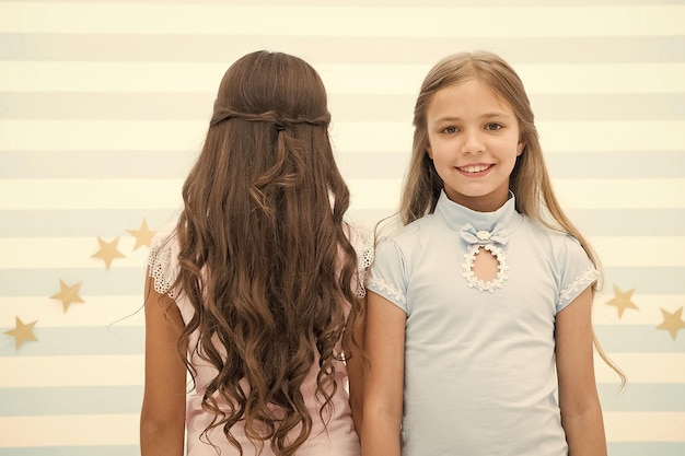 Los mejores peinados para cabello largo Lindas niñas pequeñas con largos rizos castaños y rubios en la sala de juegos Adorables niños pequeños cabello largo y suelto Disfrutando de un peinado largo y rizado