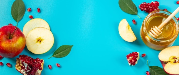 Mel de maçãs e romãs em fundo azul Feliz feriado religioso judaico de Rosh Hashanah