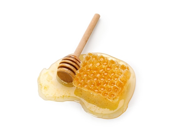 Mel em um favo de mel com dipper de pau de madeira isolado no fundo branco Produto natural de abelha