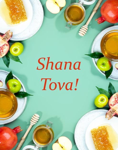 Foto mel, maçã e romã em um fundo verde-menta. feriado feliz de ano novo judaico de conceito rosh hashanah. layout criativo de símbolos tradicionais. moldura para cartões. copie o espaço. shana tova.