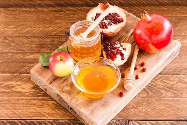 Mel, romã e maçãs na mesa de madeira. fundo de rosh hashanah feriado judaico.