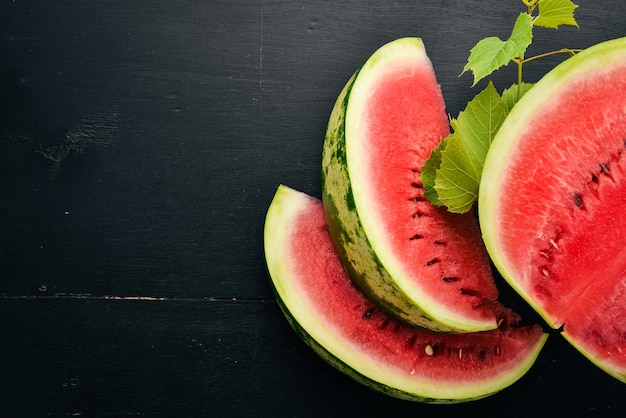 Melancia fresca Frutas Melão Em um fundo preto de madeira Espaço livre para texto Vista superior