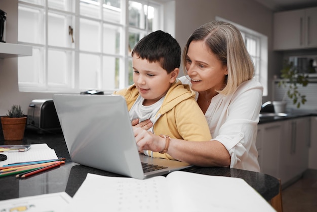 Melden wir uns für etwas Arbeit an. Aufnahme eines Mutter-Sohn-Teams, das einen Laptop verwendet, um die Hausunterrichtsarbeit zu erledigen.