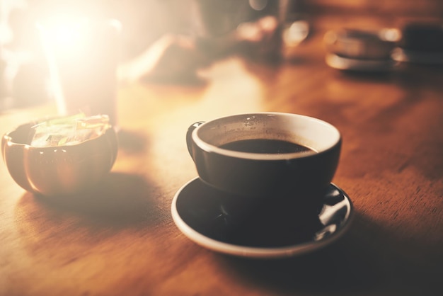 Melhor café você não encontrará Tiro de uma xícara de café acabado de fazer em uma mesa de madeira de um restaurante