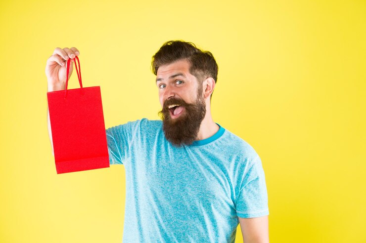 Foto melhor oferta homem com pacote de presente compre produto pouco prazer homem barbudo ir ao shopping para homens barba masculina madura com compra de moda hipster feliz segure espaço de cópia de saco de papel
