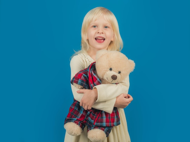 Melhor presente de todos os tempos. Pequena menina segura urso de brinquedo. Menina com ursinho de pelúcia. Criança com brinquedo macio. Criança pequena feliz sorrindo. Infância feliz. Meu brinquedo de infância favorito