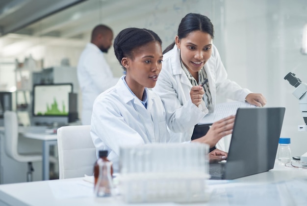 Melhorando vidas uma colaboração de cada vez Foto de dois jovens cientistas usando um laptop em um laboratório